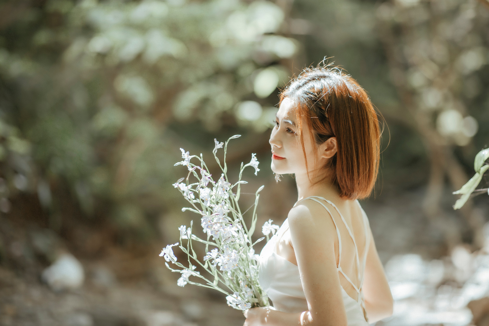 Delicate Woman Holding Flowers Outdoors 