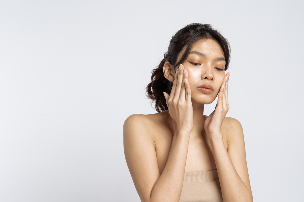 Woman Applying Facial Cream on Face